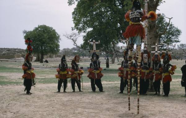 MALI, Ceremony, Dogon masked stilt dancer with others on ground below.