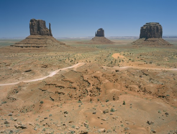 USA, Arizona, Monument Valley, Rock formations surrounded by desert and dirt roads