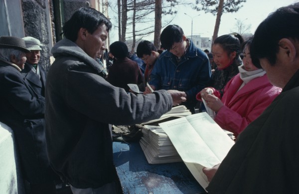 MONGOLIA, Ulaanbaatar, Newspaper vendor and customers.