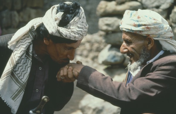 YEMEN, Jebel Aniz, Man kissing the hand of another in traditional Yemen greeting.