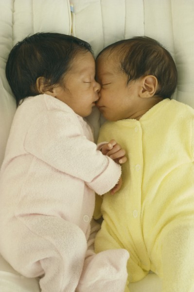 CHILDREN, Twins, "Seven week old fraternal twins in cot, facing each other with hands and faces