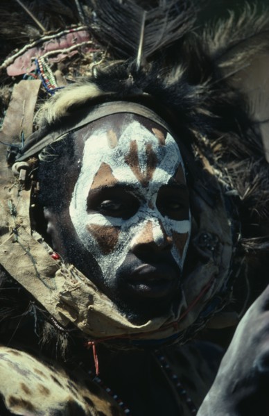 KENYA, Tribal People, Portrait of Kikuyu man with painted face and wearing fur and feather head