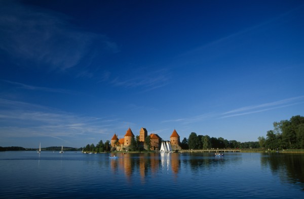 LITHUANIA, Trakai, "Wide angle view of castle reflected in lake with windswept clouds above,"