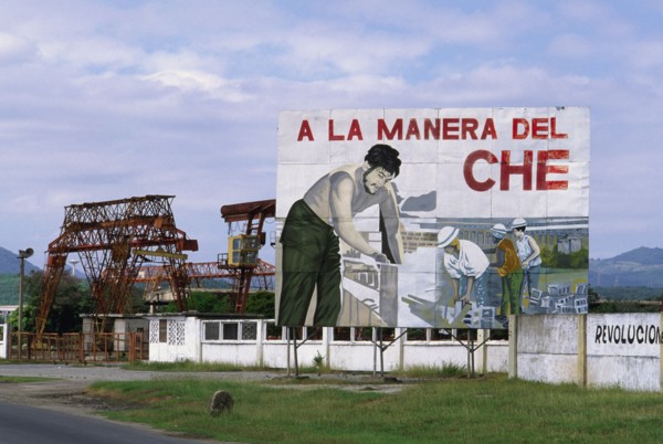 CUBA, Santiago de Cuba, "Billboard celebrating the work of Che Guevara, with industrial facilities