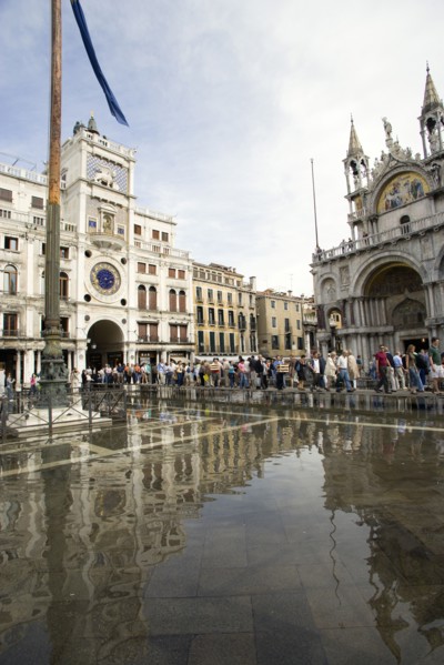 ITALY, Veneto, Venice, Aqua Alta High Water flooding in St Marks Square with tourists on elevated