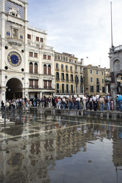 ITALY, Veneto, Venice, Aqua Alta High Water flooding in St Marks Square with tourists on elevated