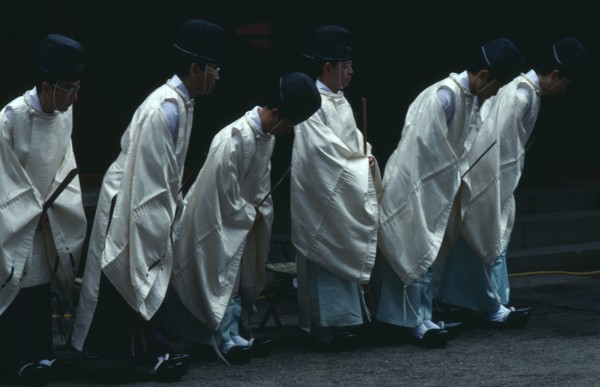 JAPAN, Honshu, Tochigi, Nikko.  Shinto priests watch and bow as the omikoshi or residence of the