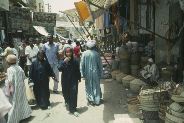 EGYPT, Aswan, Busy souk market scene with pulse vendor and crowds walking by.