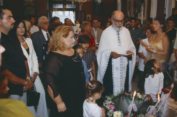 GREECE, Cyclades Islands, Syros, "A Greek orthodox christening, The Priest reads with friends and