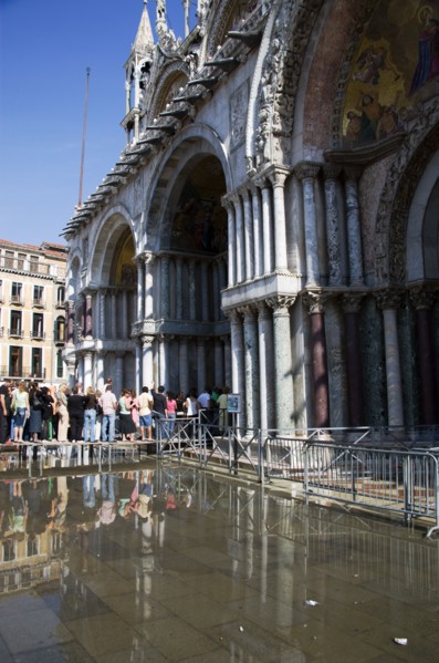 ITALY, Veneto, Venice, Aqua Alta High Water flooding in St Marks Square with tourists queuing on