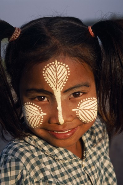 MYANMAR, Amarapura, Head and shoulders portrait of young girl at U Bein Bridge near Mandalay