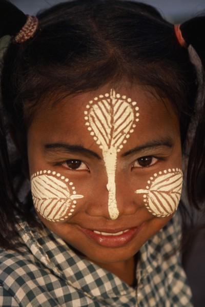 MYANMAR, Amarapura, Head and shoulders portrait of young girl at U Bein Bridge near Mandalay