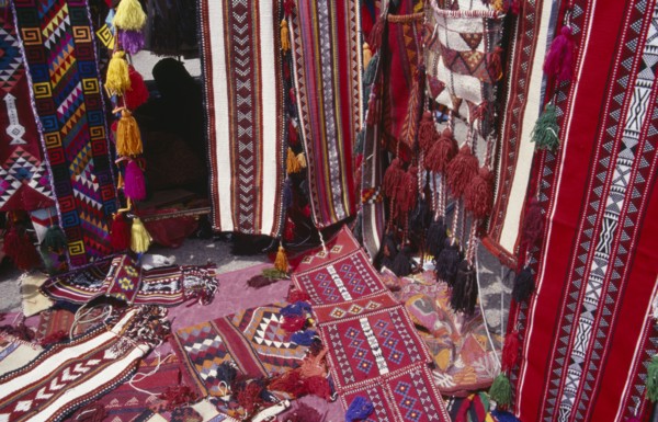 KUWAIT, Kuwait City, Brightly coloured Bedouin textiles for sale at Friday Market.
