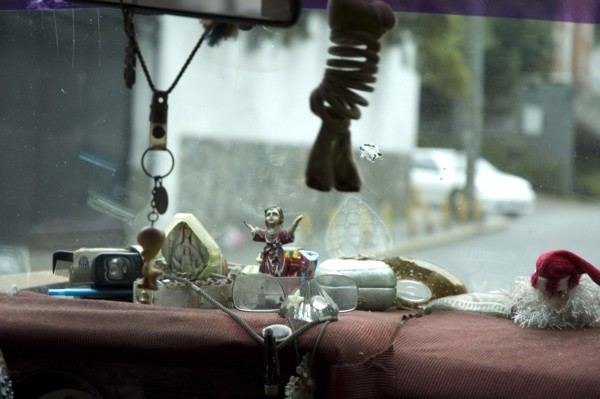 VENEZUELA, Caracas , "Dashboard of Caracas taxi including religious artefacts, a comb and reading