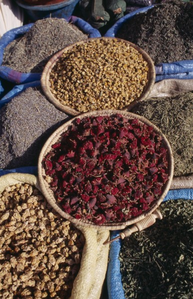 MOROCCO, Marrakech, Baskets of dried flower heads and leaves for sale at market.