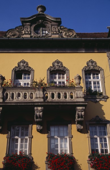 HUNGARY, Budapest, Detail of yellow painted facade of town building with stone balconies and window