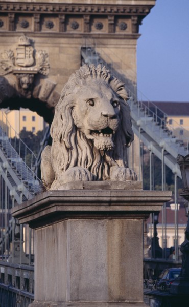 HUNGARY, Budapest, Stone statue of lion on Chain Bridge. Eastern Europe