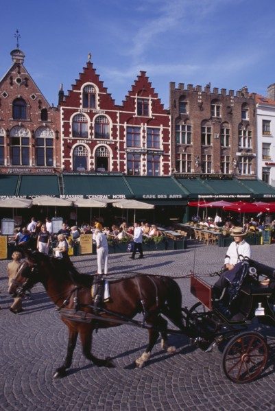 BELGIUM, West Flanders, Bruges, The Markt (Market Place).  Horse drawn carriage passing line of