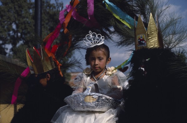 MEXICO, Tlaxcala, Little girl dressed in white flanked by two masked attendants in costume on float