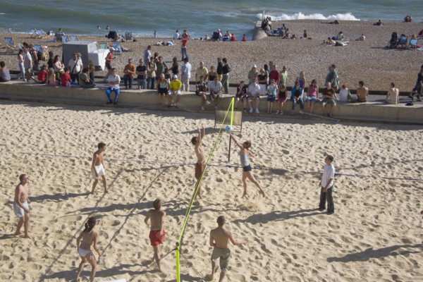 ENGLAND, East Sussex, Brighton, Beach volleyball game on the sands in front of the Grand Hotel.