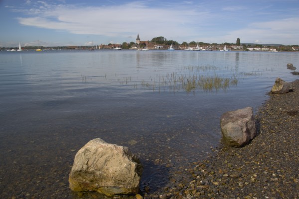 ENGLAND, West Sussex, Bosham, View across water toward Old Bosham with the church spire visible