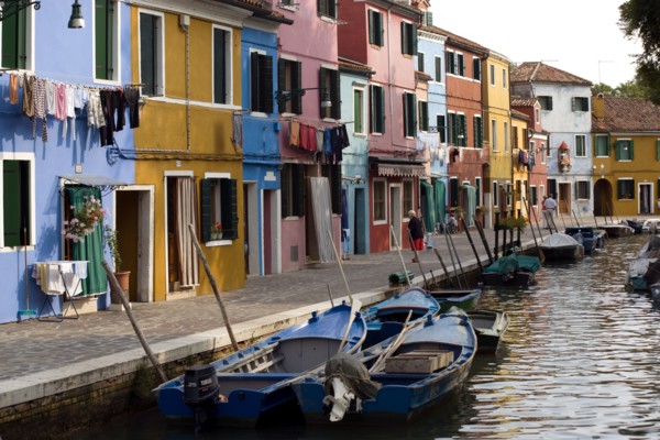 ITALY, Veneto, Venice, Colourful houses beside a canal on the lagoon island of Burano with tourists