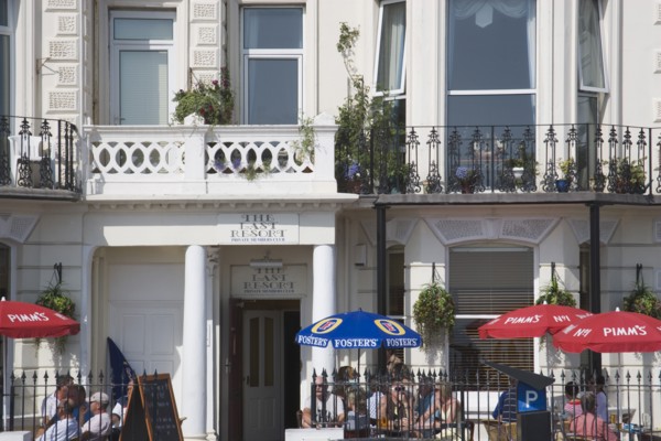 ENGLAND, West Sussex, Worthing, The Last Resort seafront bar exterior with people sitting under
