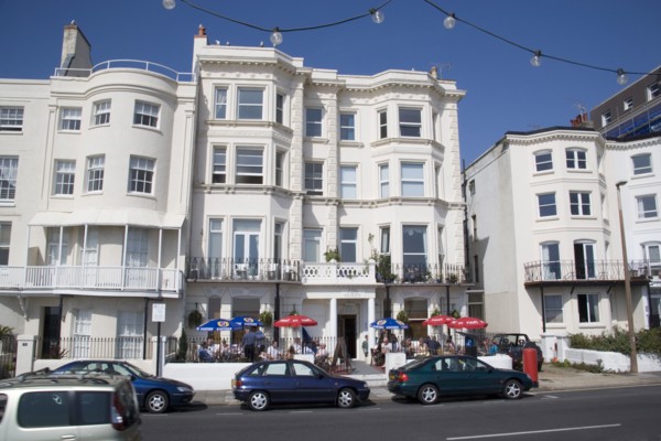 ENGLAND, West Sussex, Worthing, The Last Resort seafront bar exterior with people sitting  under
