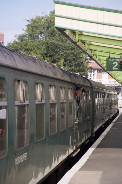 ENGLAND, Dorset, Swanage, Steam Railway Station. View along platform with train departing from