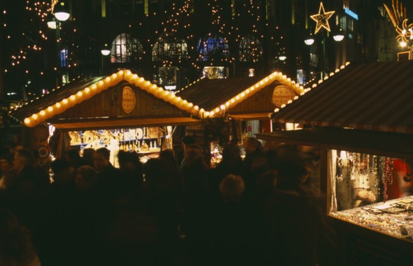 GERMANY, Berlin, Breitscheidplatz. Christmas Market. People gathered around Illuminated stalls at