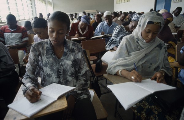 NIGERIA, Kano, Students writing at desks in law school.