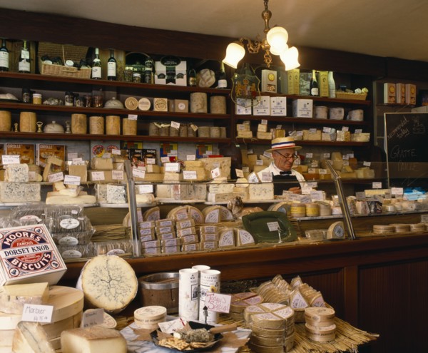FOOD, Cheese, Man behind counter of specialist cheese delicatessen