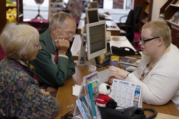 ENGLAND, West Sussex, Chichester, Male and female customer in a Travel Agents office discussing