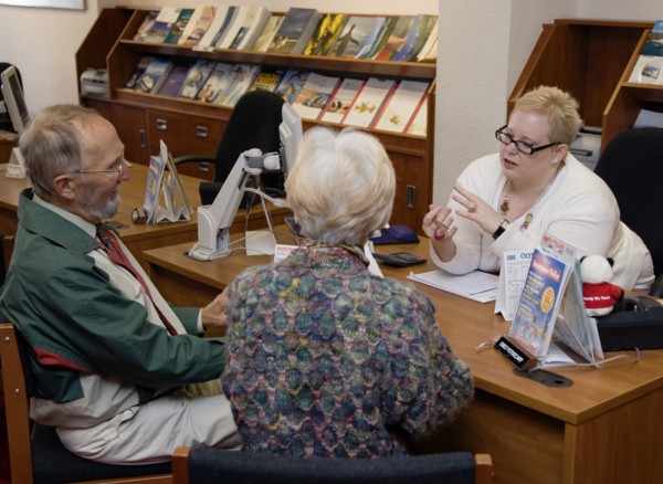 ENGLAND, West Sussex, Chichester, Male and female customer in a Travel Agents office discussing