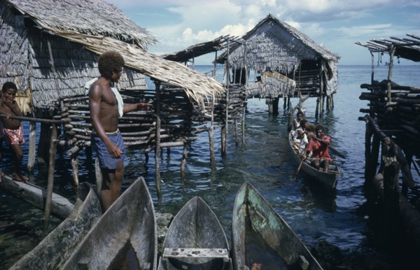 PACIFIC ISLANDS, Melanesia, Solomon Islands, Thatched stilt houses on artificial island with man
