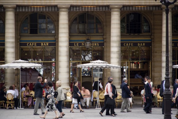 FRANCE, Ile de France, Paris, People at tables with pedestrians walking past outside the Cafe Bar