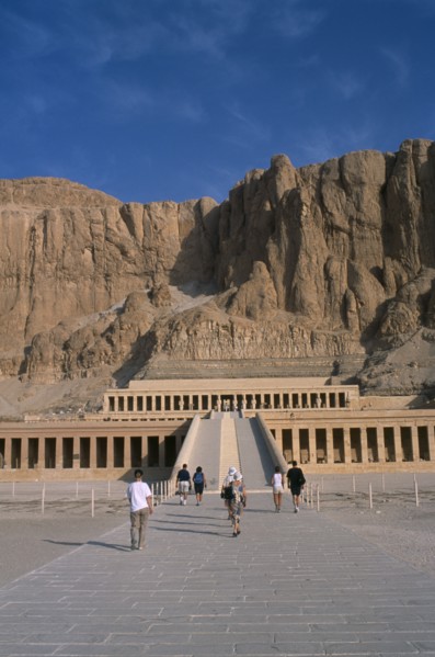 EGYPT, Nile Valley, Thebes, Deir el-Bahri. Hatshepsut Mortuary Temple. Visitors walking towards