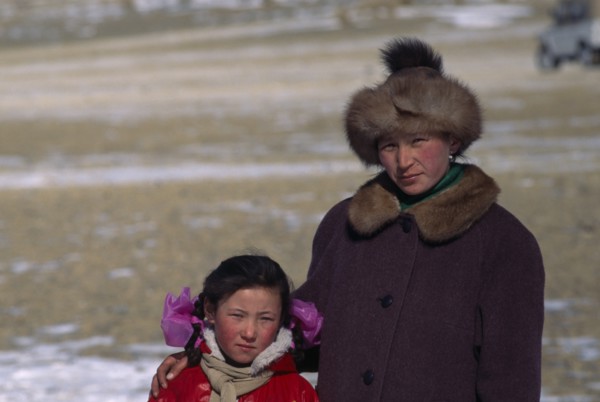 MONGOLIA, Bayan Olgii Province, Kazakh, Portrait of Kazakh woman and her daughter watching the