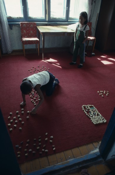 MONGOLIA, Children, Children playing indoors with sheep knuckle bones used to represent herds and
