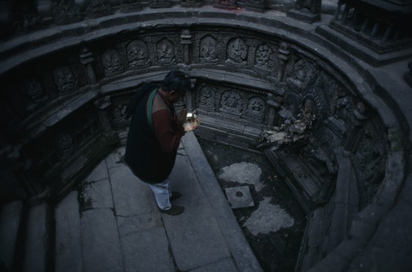NEPAL, Kathmandu, "Man worshipping in sunken tank and former royal bath known as Tusha Hiti in