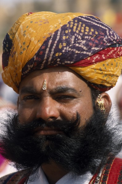 INDIA, Rajasthan, Jaisalmer, Head and shoulders portrait of a Mr Desert contestant with a beard