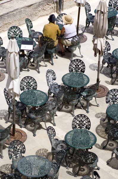 MALTA, Valletta, Couple of people sitting at a table amongst other wrought iron tables and chairs
