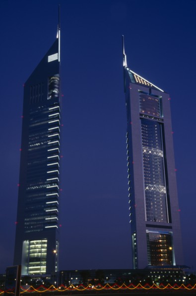 UAE, Dubai , Emirates Tower illuminated at night with coloured lights in the foreground.