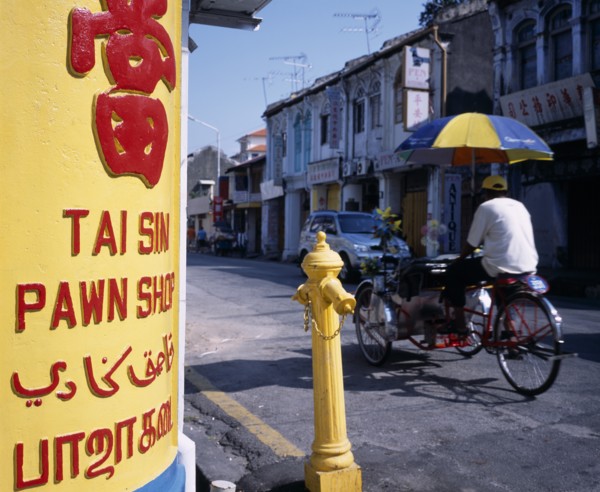 MALAYSIA, Penang, Georgetown, Lebuh Chulia.  Cycle rickshaw on street with yellow and red painted