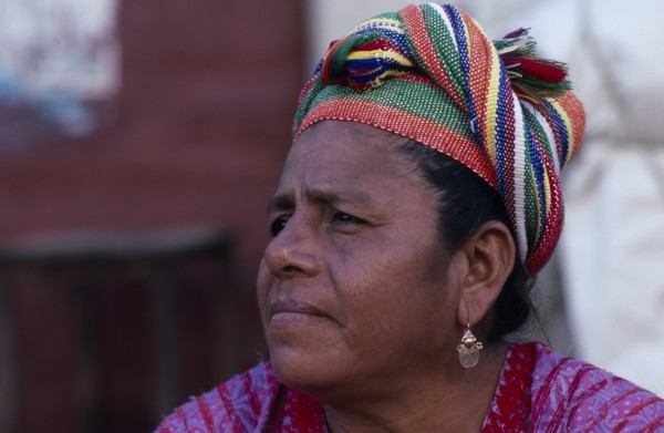 MEXICO, Oaxaca, Juchitan, Head and shoulders portrait of woman wearing coloured headscarf and gold