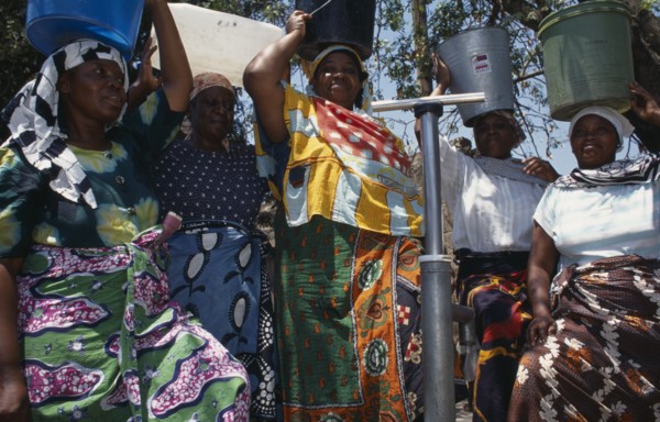 20088822 TANZANIA  Shinyanga Women at standpipe carrying pails of clean water on their heads.  Following 1994 cholera outbreak an urban health programme was set up to teach health awareness.