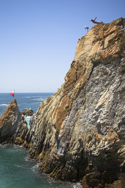 MEXICO, Guerrero State, Acapulco, "Cliff diver, a clavadista, diving off the cliffs at La Quebrada"