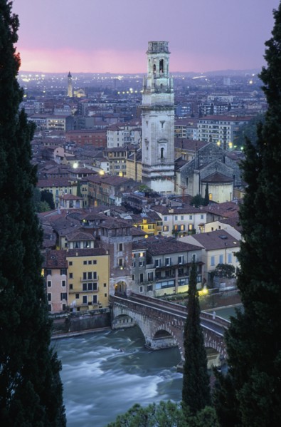 ITALY, Veneto, Verona, "Cityscape at sunset showing tiled rooftops, Duomo bell tower and bridge