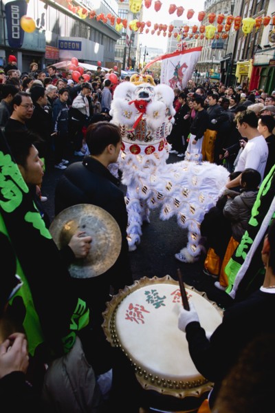 ENGLAND, London, Chinatown, Lion Dance troupe performing in Wardour Street amongst the crowd