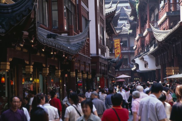 CHINA, Shanghai, "Yu Gardens, Old City.  Crowds of shoppers in narrow street lined with shop fronts